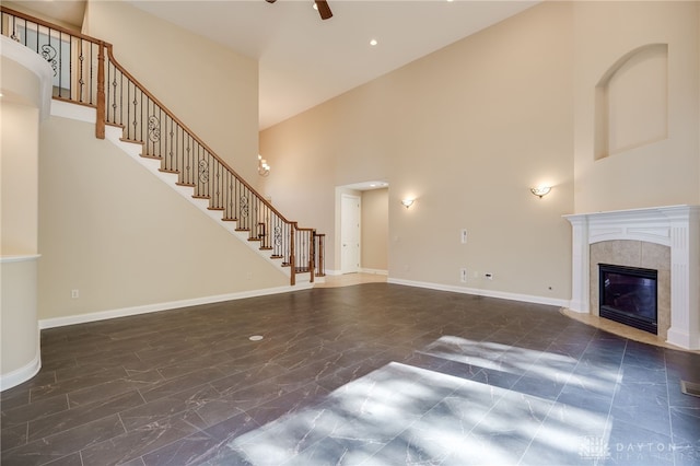 unfurnished living room featuring ceiling fan, high vaulted ceiling, and a tile fireplace