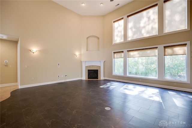 unfurnished living room with a high ceiling and plenty of natural light