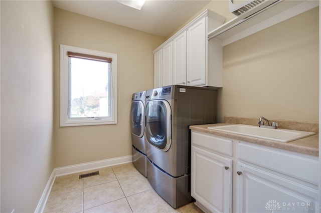 laundry room with light tile patterned floors, sink, separate washer and dryer, and cabinets