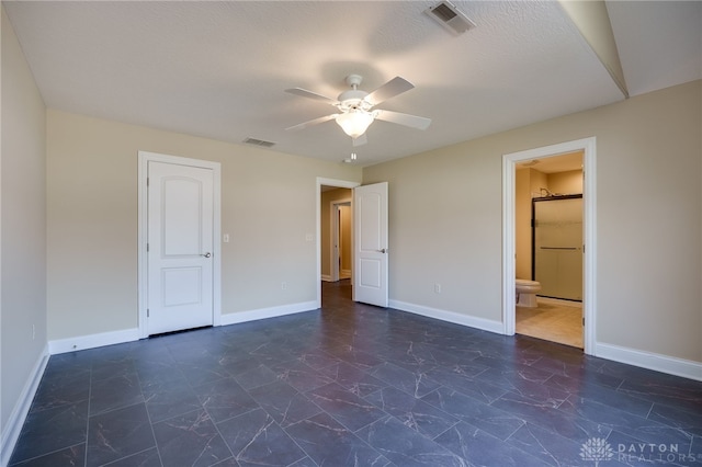 unfurnished bedroom with ensuite bath, a textured ceiling, a closet, and ceiling fan