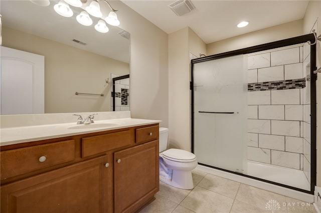 bathroom featuring vanity, a shower with shower door, toilet, and tile patterned flooring