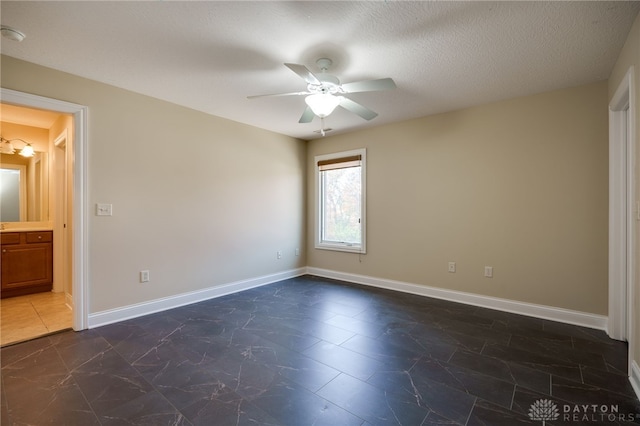 unfurnished bedroom featuring connected bathroom, ceiling fan, and a textured ceiling