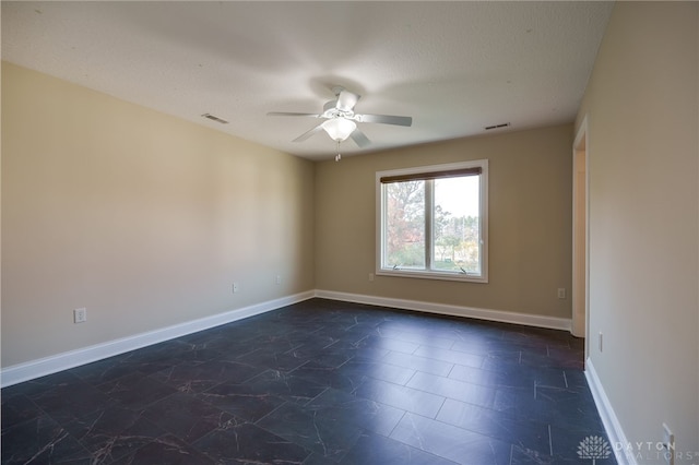 spare room with a textured ceiling and ceiling fan