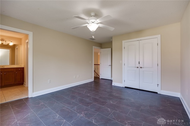 unfurnished bedroom with a closet, a textured ceiling, connected bathroom, and ceiling fan