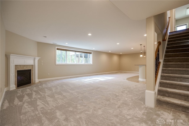 basement featuring light colored carpet and a tile fireplace