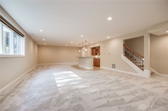 unfurnished living room with bar and light colored carpet