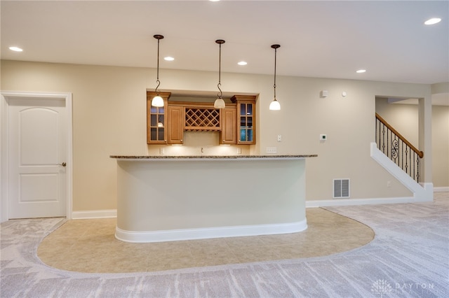 bar featuring light carpet, stone counters, and pendant lighting