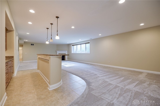 kitchen with a kitchen breakfast bar, hanging light fixtures, and light colored carpet