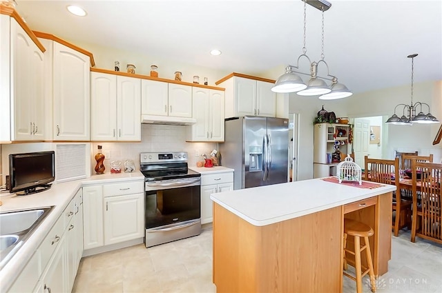 kitchen with backsplash, stainless steel appliances, a center island, white cabinetry, and hanging light fixtures