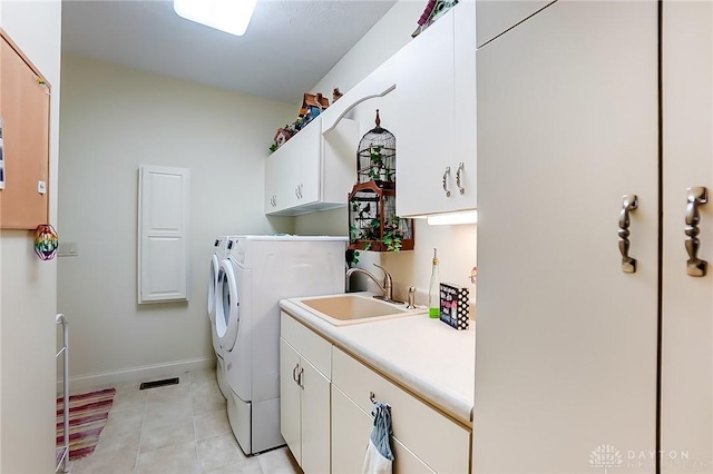 laundry area featuring separate washer and dryer, sink, and cabinets