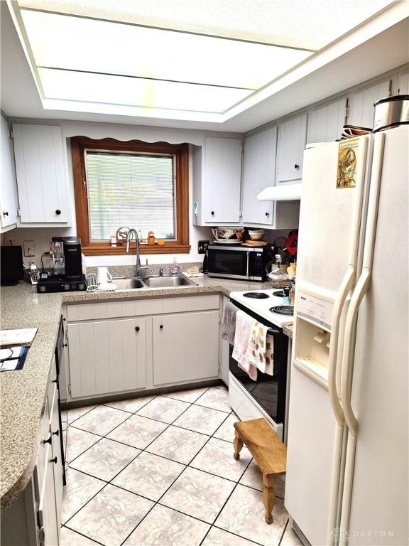 kitchen featuring sink, white appliances, and light tile patterned floors