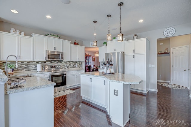 kitchen featuring white cabinetry, appliances with stainless steel finishes, and dark hardwood / wood-style floors