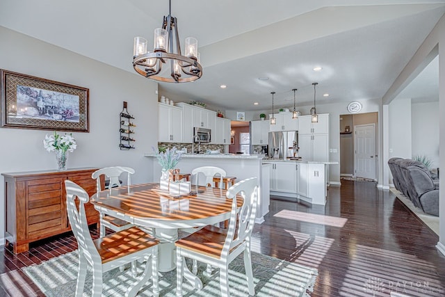 dining area featuring dark hardwood / wood-style floors and an inviting chandelier