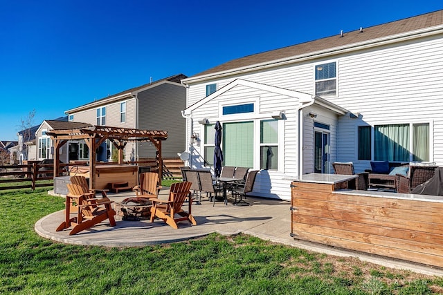 rear view of house featuring an outdoor fire pit, a hot tub, a patio, a lawn, and a pergola