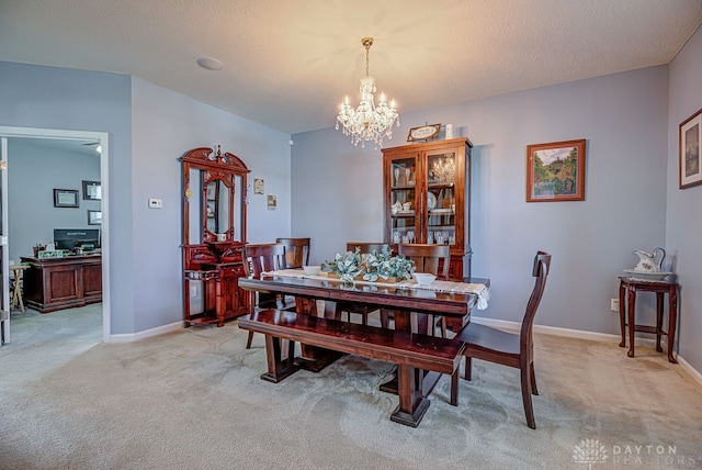 dining room with an inviting chandelier, light colored carpet, and a textured ceiling