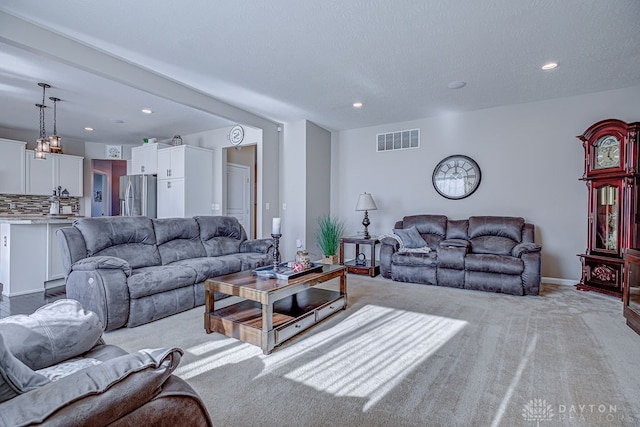 carpeted living room featuring a textured ceiling