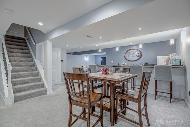 carpeted dining space with bar area