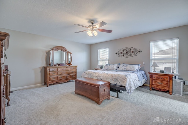 carpeted bedroom featuring multiple windows and ceiling fan