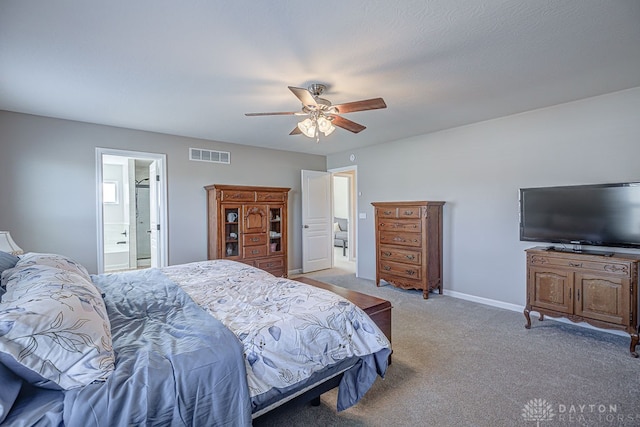 bedroom featuring ensuite bathroom, light carpet, and ceiling fan