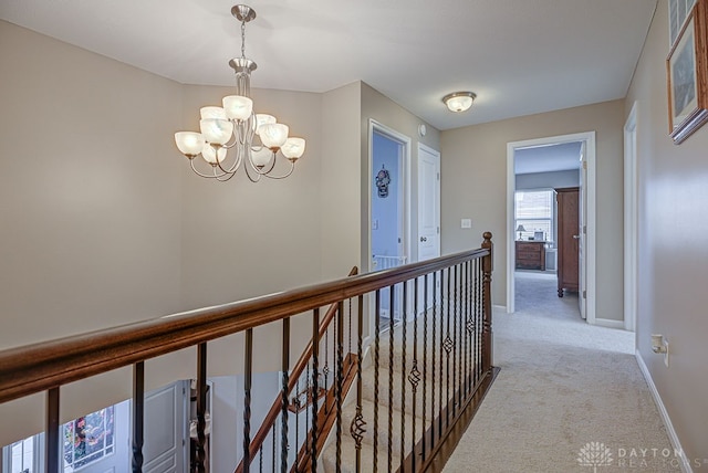 hall with light colored carpet and a chandelier