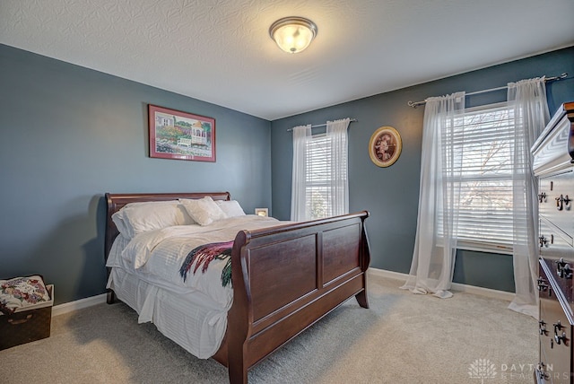 carpeted bedroom with a textured ceiling and multiple windows