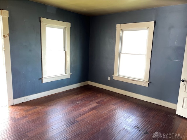 unfurnished room with dark hardwood / wood-style flooring