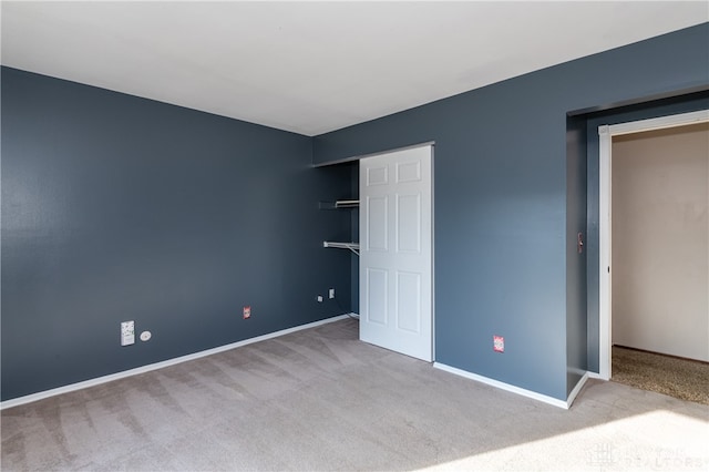 unfurnished bedroom with light colored carpet and a closet