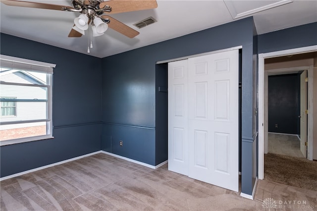 unfurnished bedroom featuring light carpet, a closet, and ceiling fan