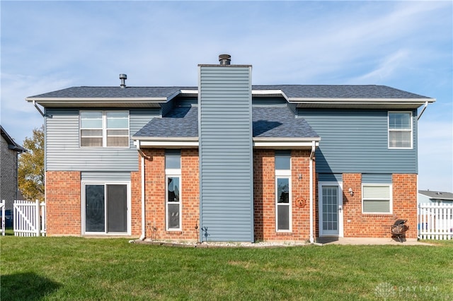 rear view of house featuring a lawn