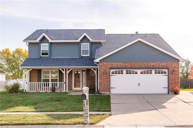 view of front facade with covered porch, a front yard, and a garage