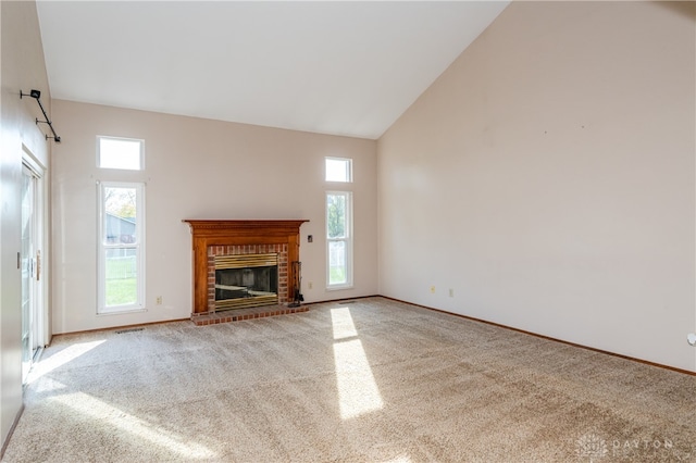 unfurnished living room with high vaulted ceiling, a brick fireplace, and light colored carpet