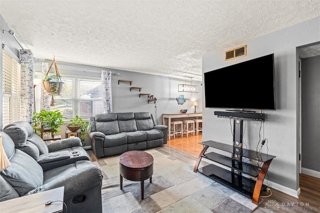 living room with wood-type flooring and a textured ceiling