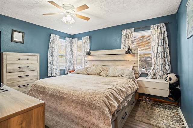 bedroom with ceiling fan, dark hardwood / wood-style flooring, and a textured ceiling