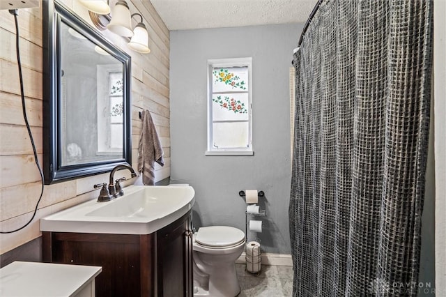 bathroom featuring walk in shower, a textured ceiling, toilet, wooden walls, and vanity