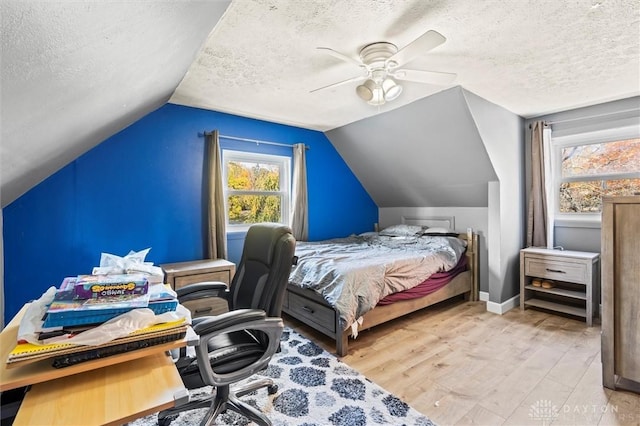 bedroom featuring a textured ceiling, light hardwood / wood-style flooring, ceiling fan, and vaulted ceiling