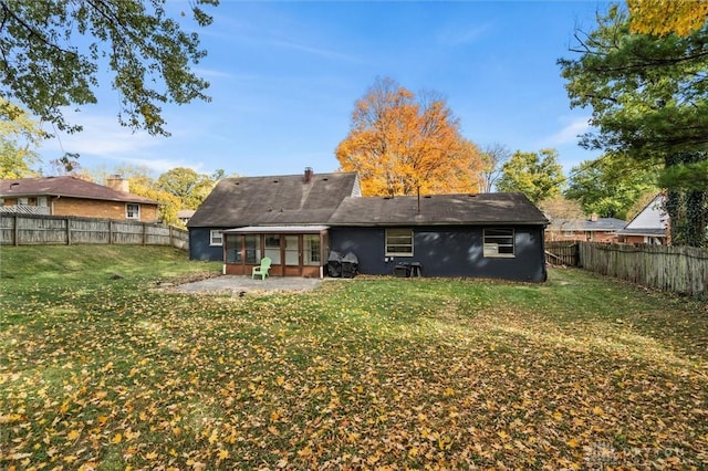 back of property featuring a sunroom, a yard, and a patio