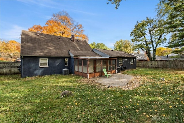 back of property featuring a yard, central air condition unit, a patio area, and a sunroom