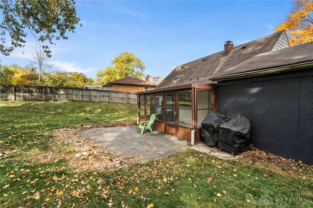 view of yard featuring a sunroom and a patio area