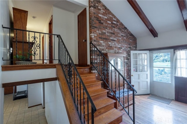 stairs featuring vaulted ceiling with beams and hardwood / wood-style flooring