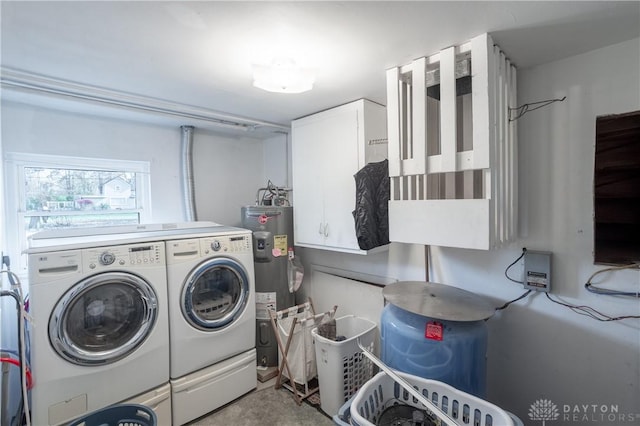 laundry room featuring cabinets, washing machine and dryer, and water heater