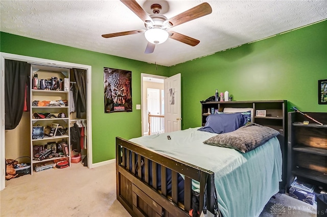 carpeted bedroom featuring ceiling fan, a textured ceiling, and a closet