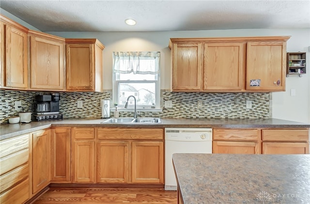 kitchen featuring dishwasher, light hardwood / wood-style flooring, sink, and tasteful backsplash