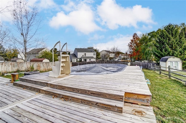 wooden deck featuring a yard and a storage unit