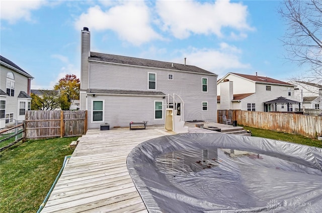 back of property featuring a deck and a yard