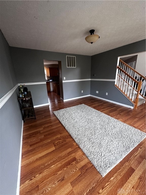 living room featuring a textured ceiling and dark wood-type flooring