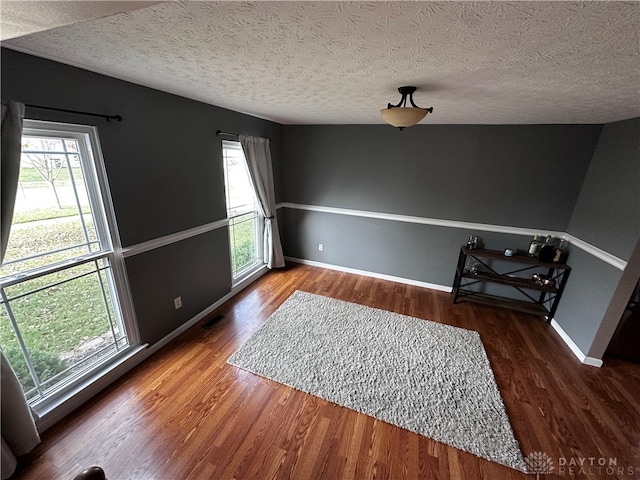 interior space with dark hardwood / wood-style flooring and a textured ceiling