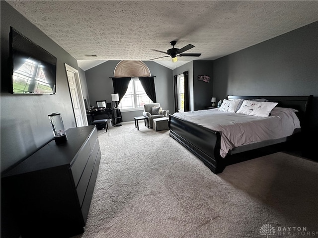 bedroom featuring carpet flooring, a textured ceiling, vaulted ceiling, and ceiling fan