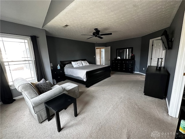 carpeted bedroom featuring a textured ceiling and ceiling fan