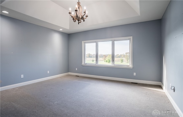 spare room with carpet floors and a chandelier