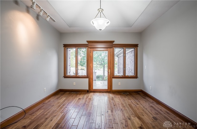 doorway to outside with track lighting and hardwood / wood-style floors